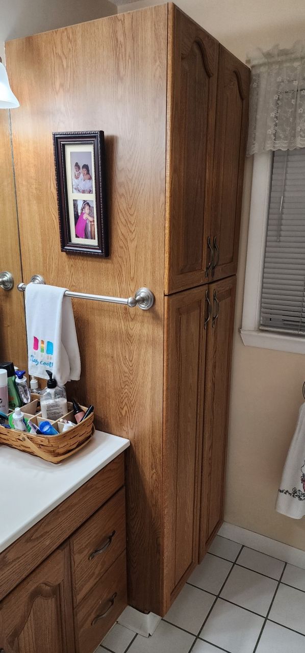 There is a picture on the wall above the sink in the bathroom.