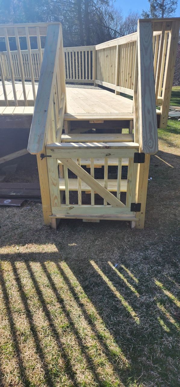A wooden bridge is being built in the grass.