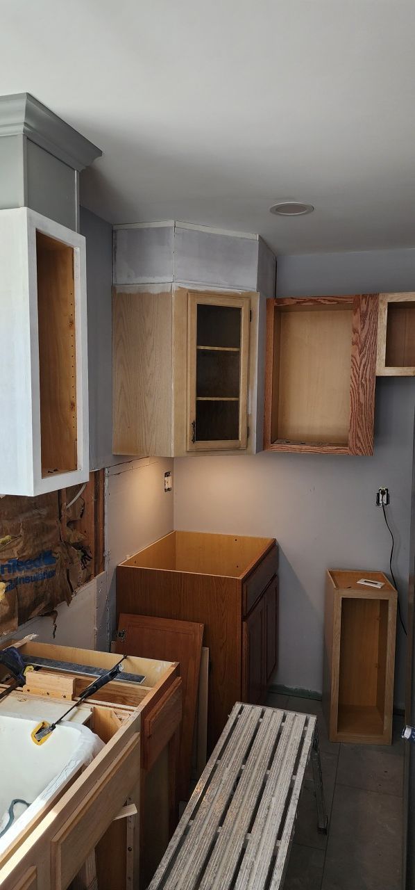 A kitchen under construction with wooden cabinets and a table.