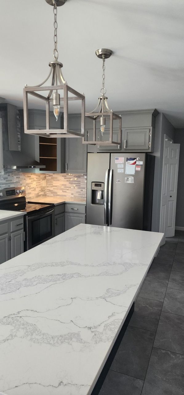 A kitchen with a large island and a refrigerator.