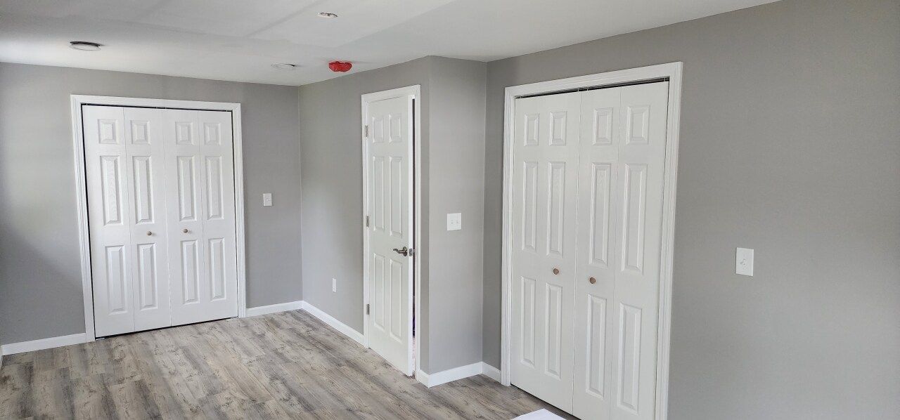 A room with a lot of doors and a wooden floor.