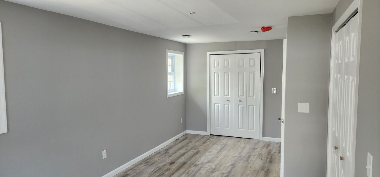 An empty room with gray walls and white doors.
