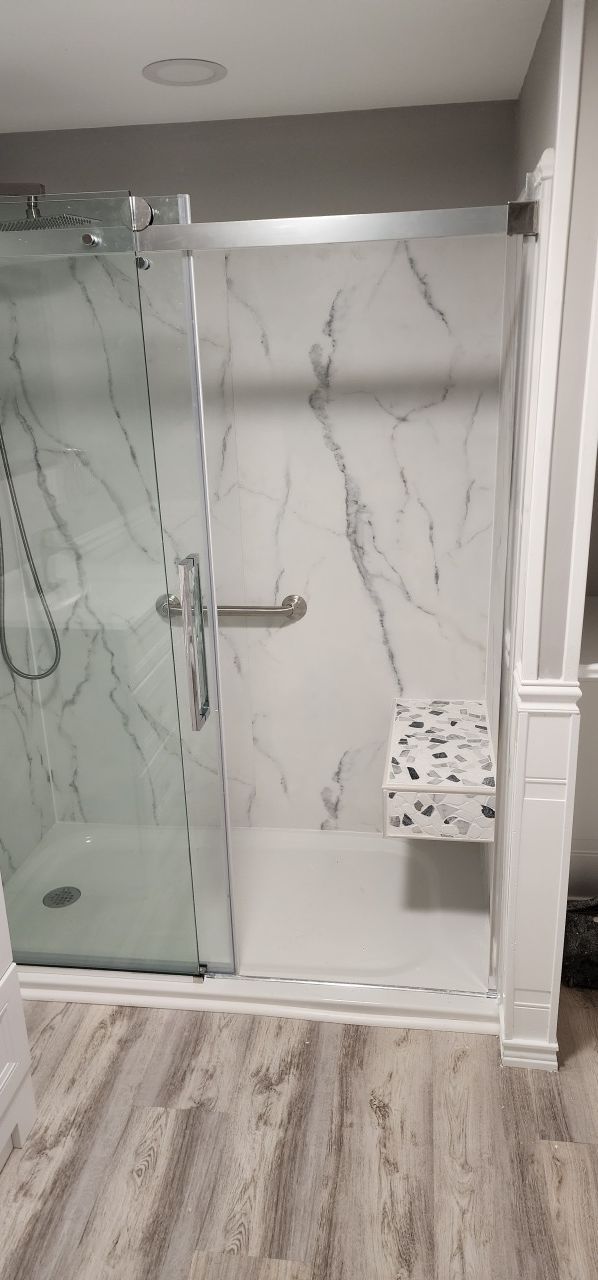 A bathroom with a walk in shower and a bench.