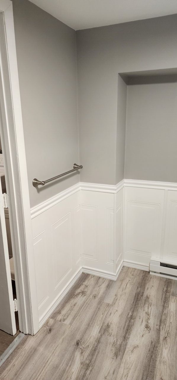 A bathroom with gray walls and a wooden floor.