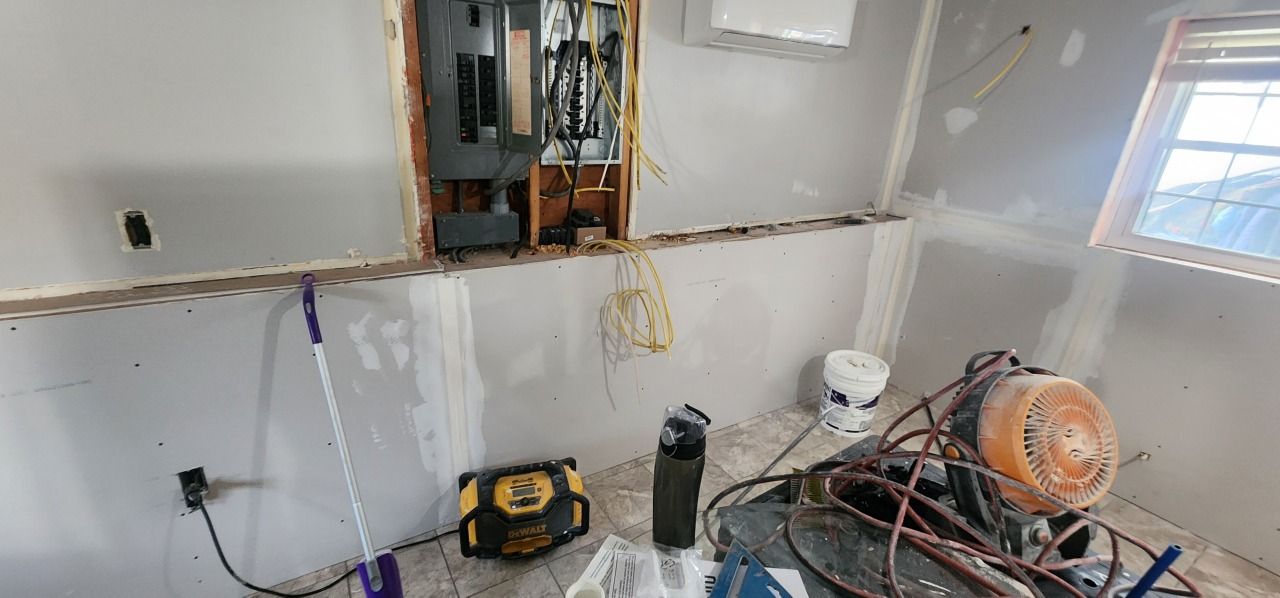 A room with a lot of wires hanging from the walls and a window.