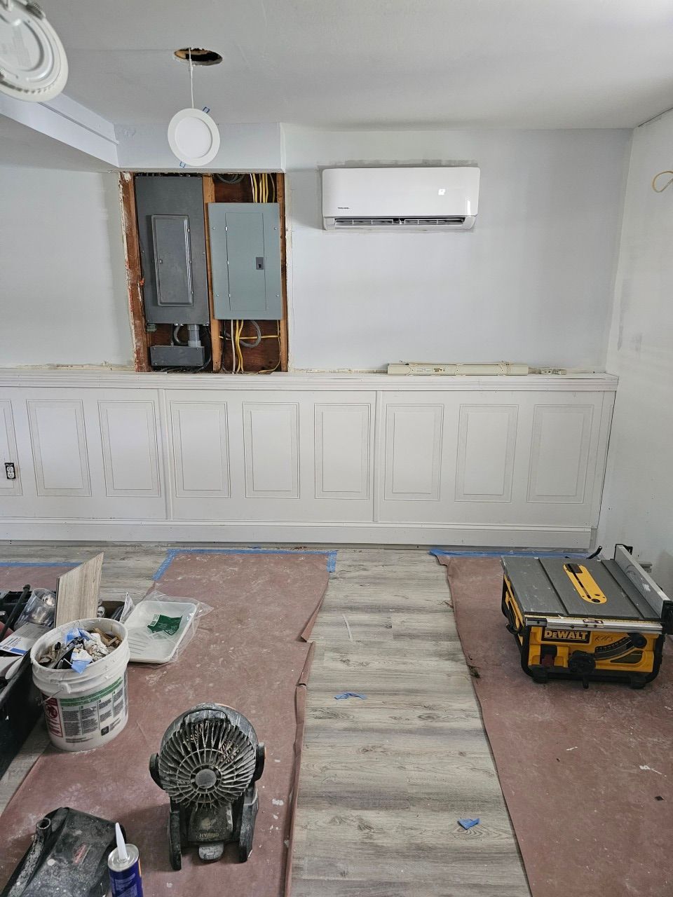 A room that is being remodeled with a fan and a table.