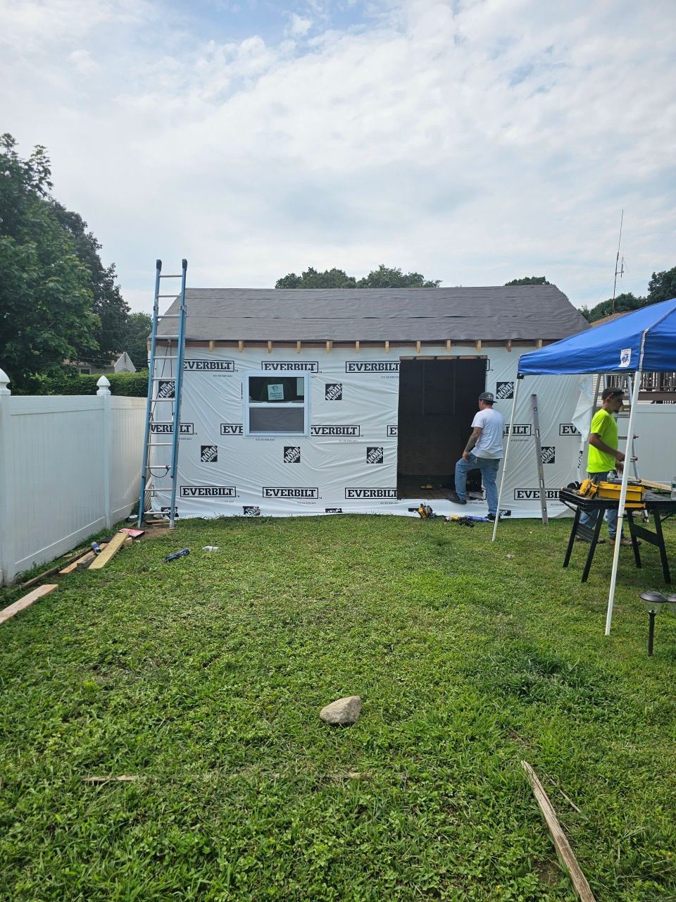 A shed is being built in the backyard of a house.