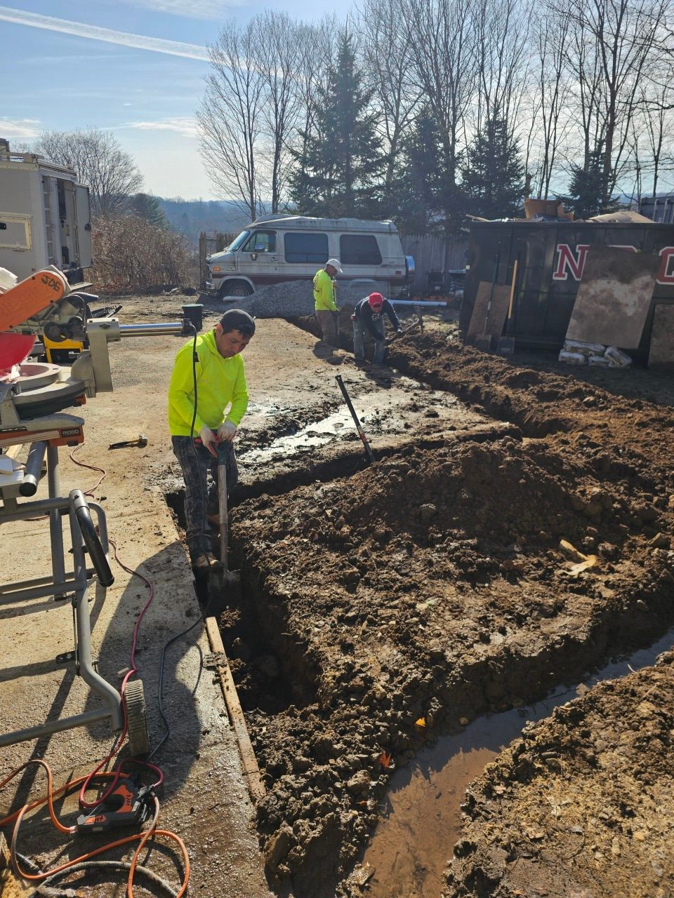 A man is digging a hole in the dirt with a shovel.