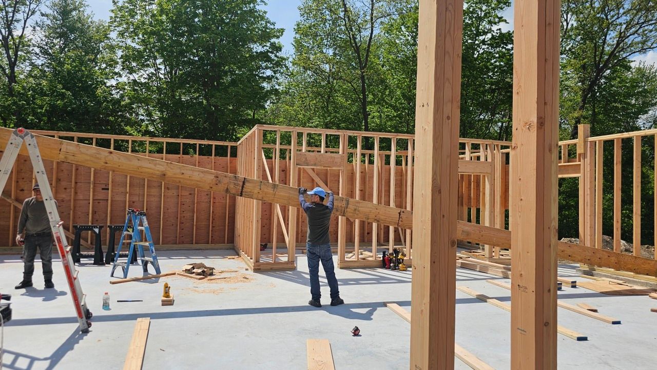 A group of construction workers are working on a house under construction.