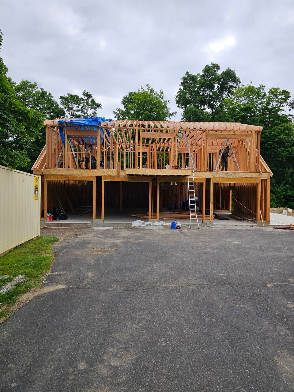 A large house is being built in the middle of a parking lot.