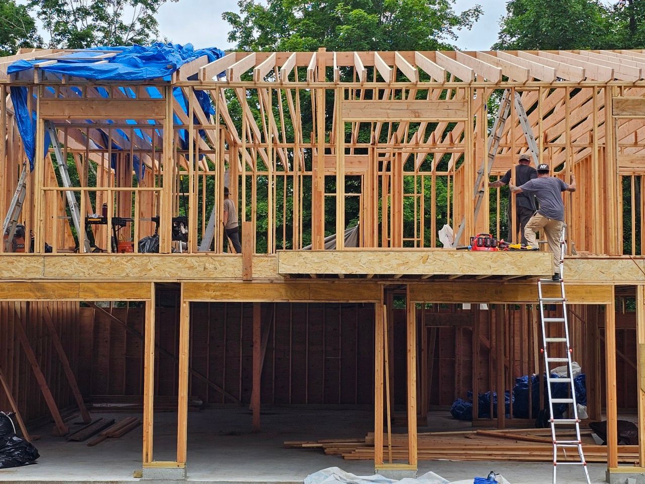 A man is working on the roof of a house under construction