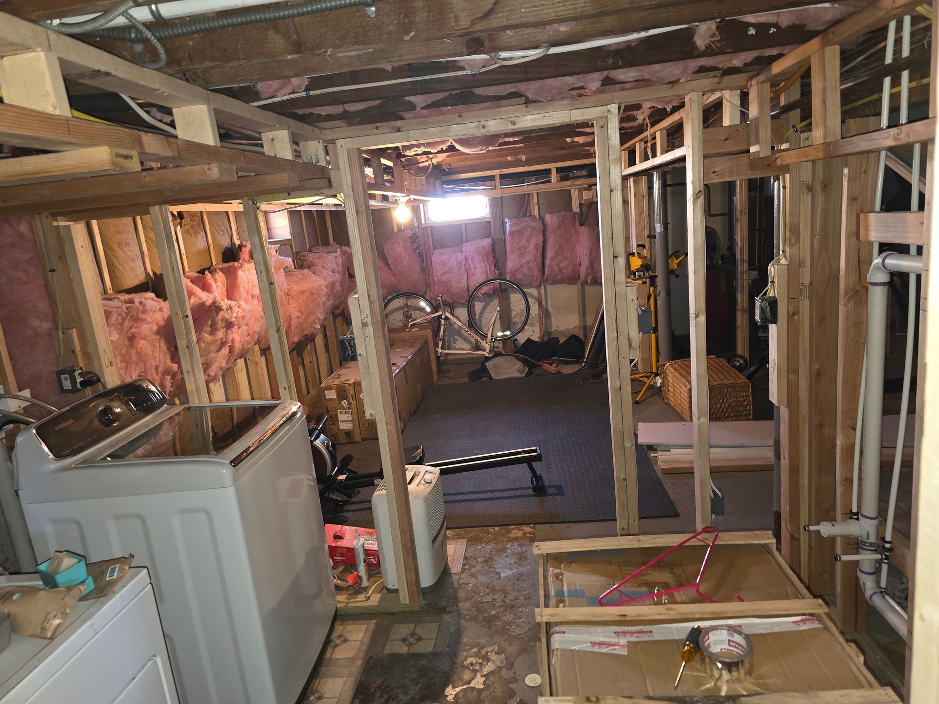 A laundry room under construction with a washer and dryer.