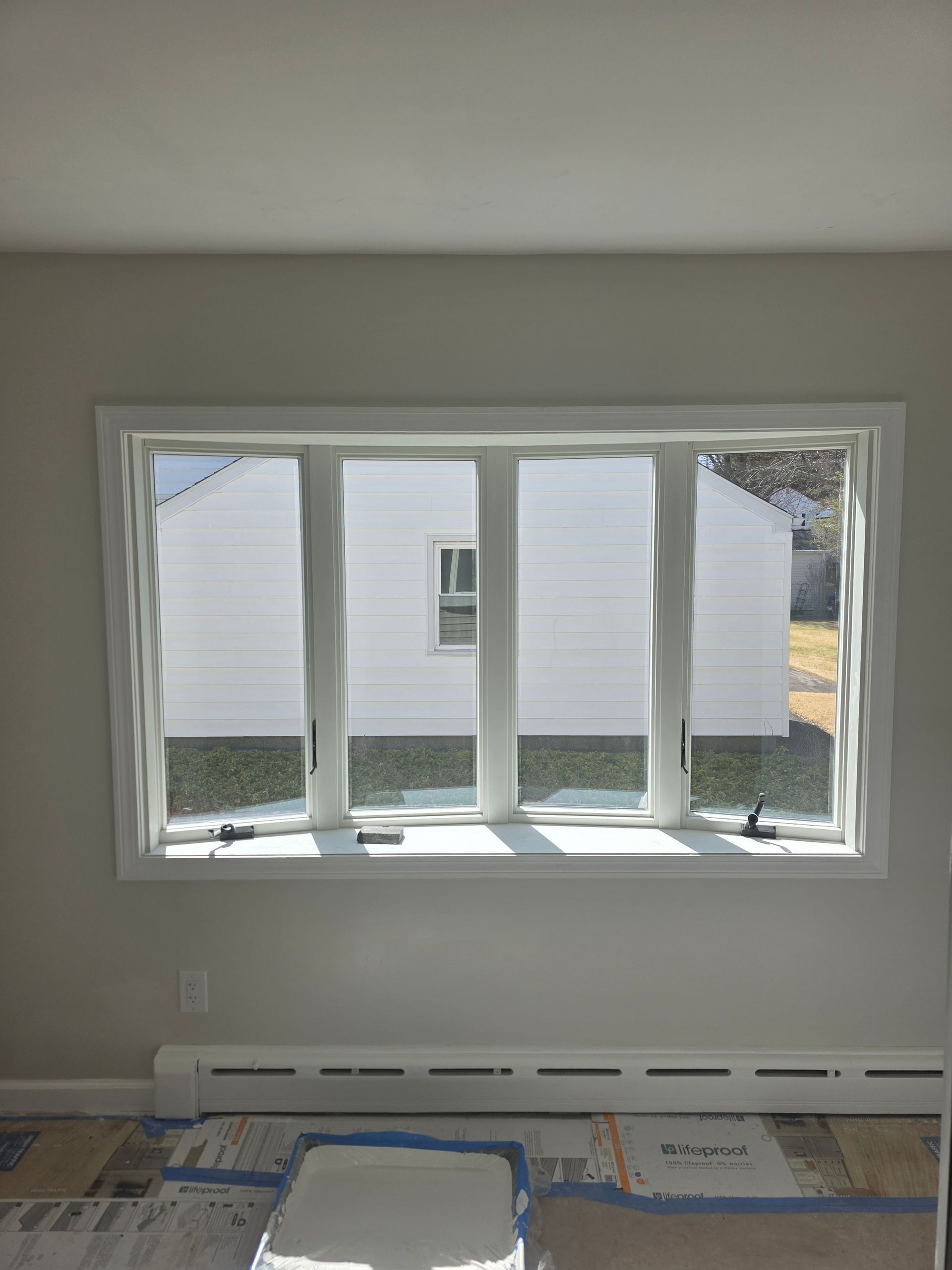 A large window in a room with a view of a white house.