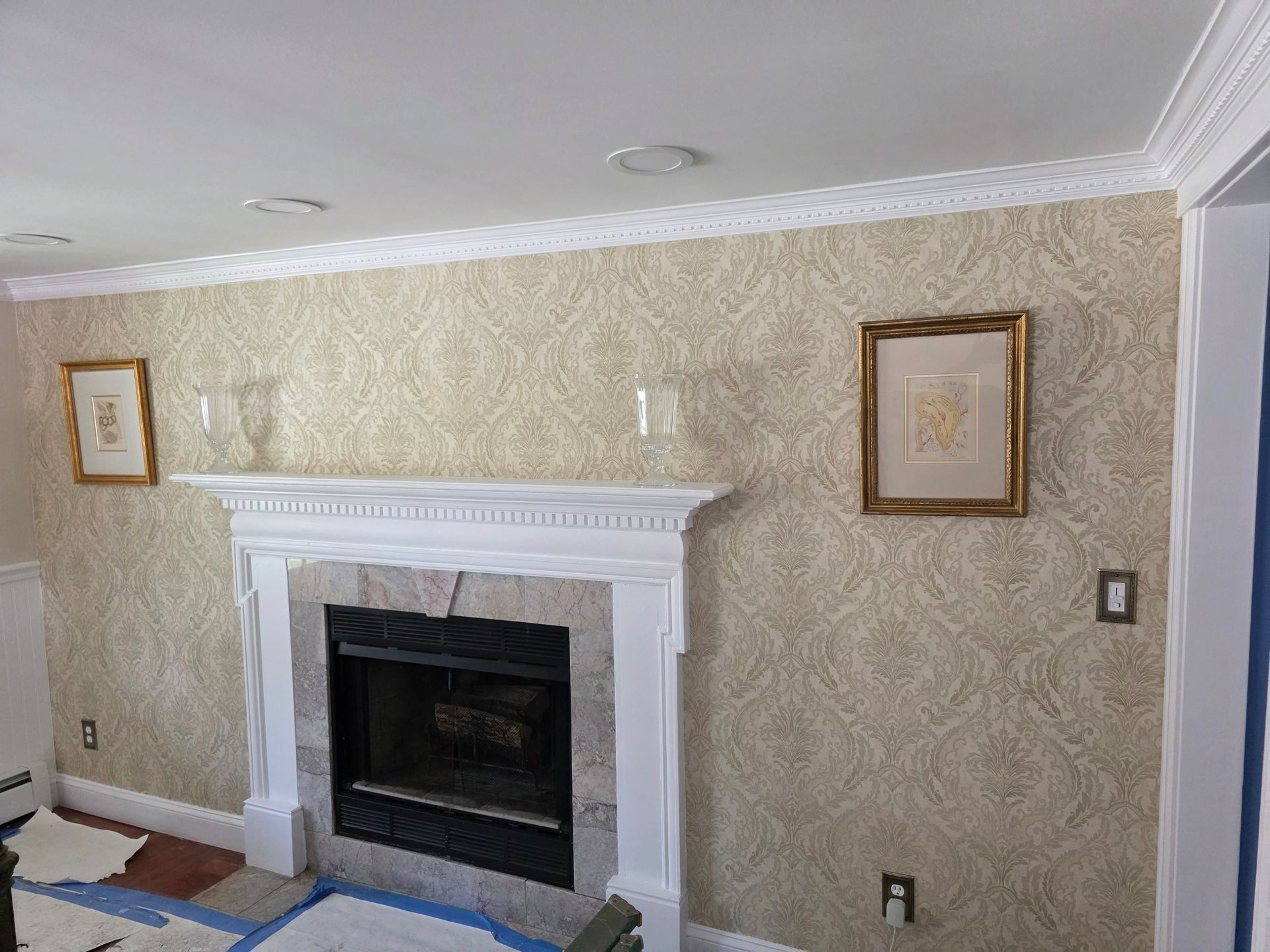 A living room with a fireplace and pictures on the wall.