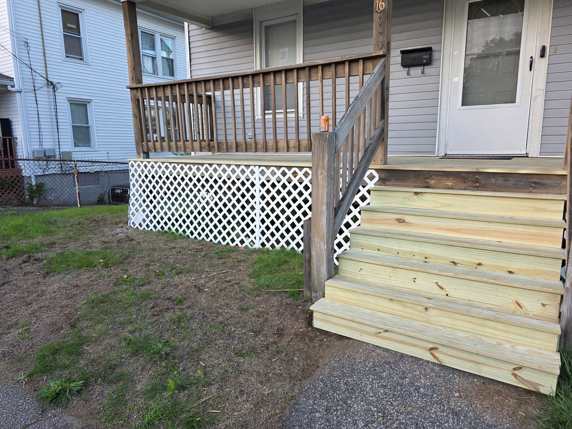 A house with a wooden deck and stairs in front of it.