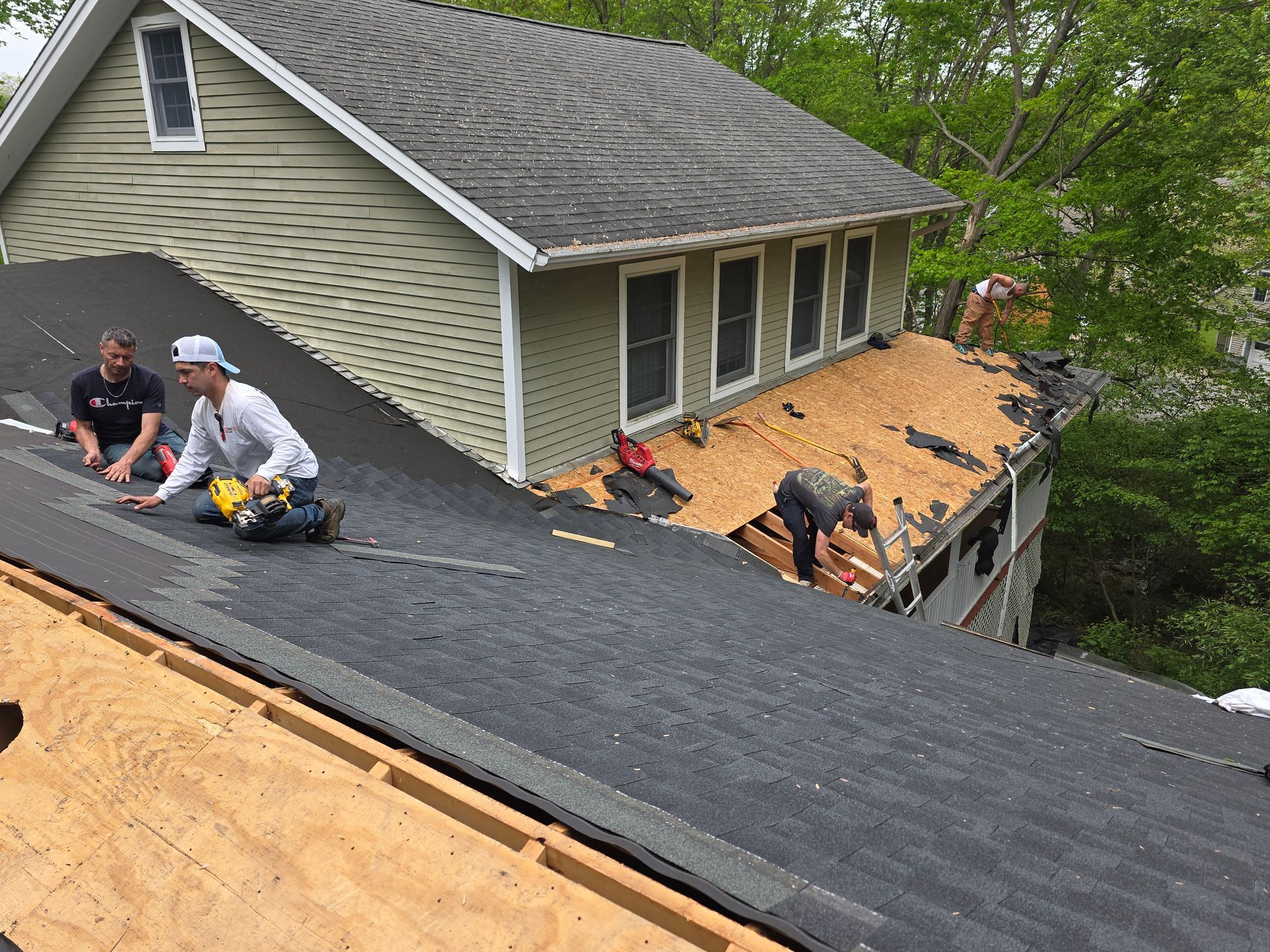 Two men are working on the roof of a house.