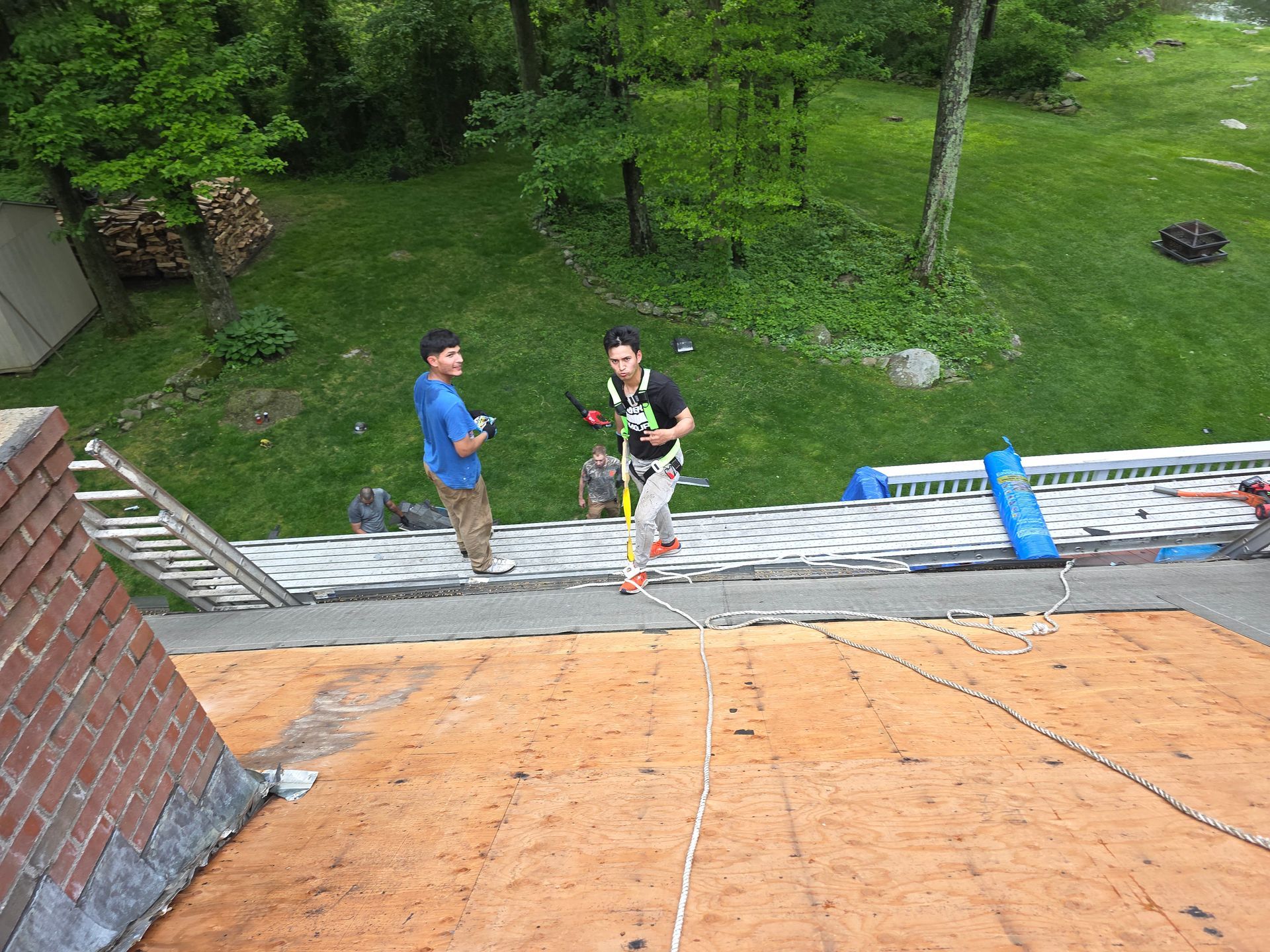Two men are standing on top of a roof.