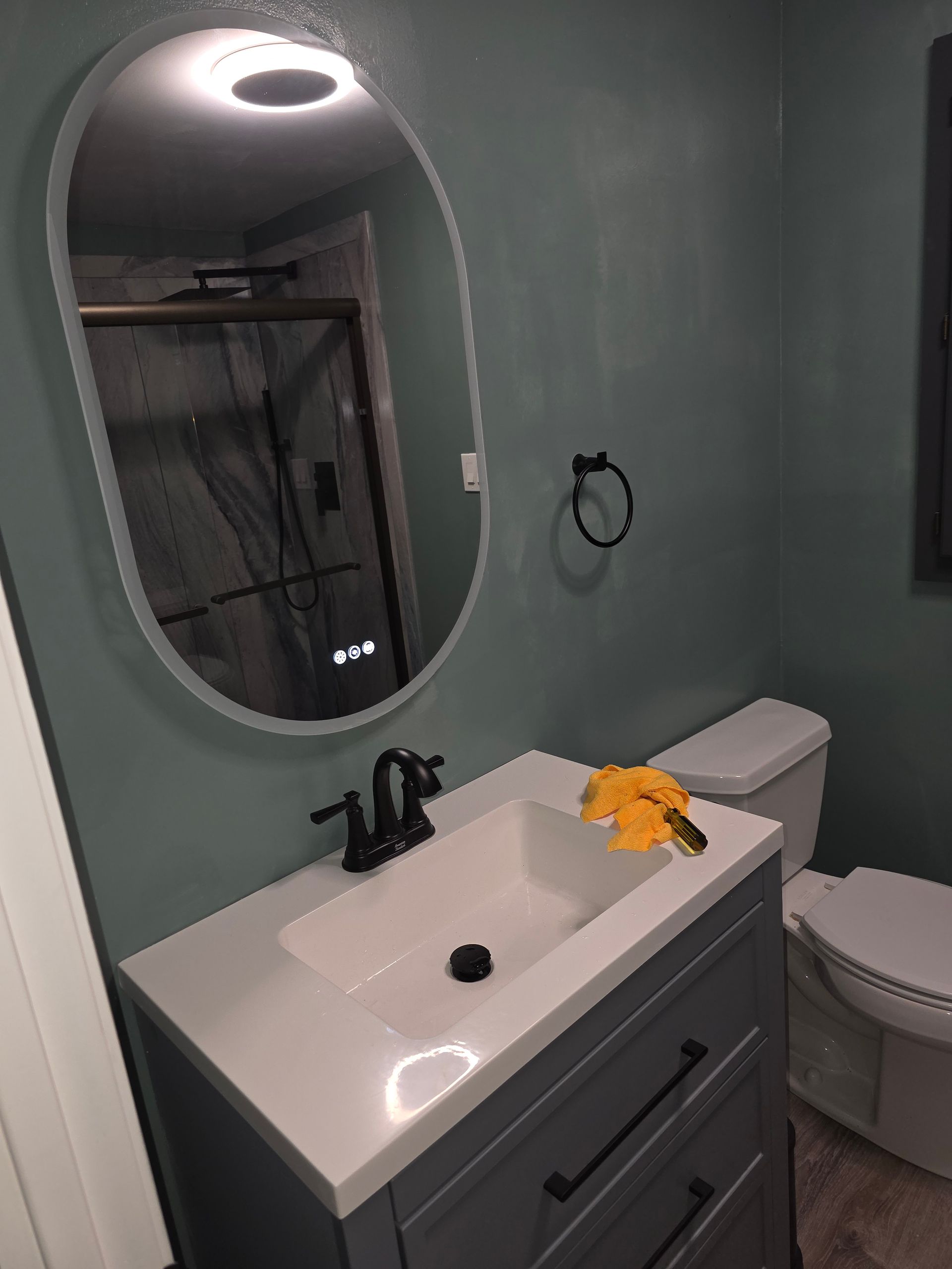 A bathroom with a sink , toilet and mirror.