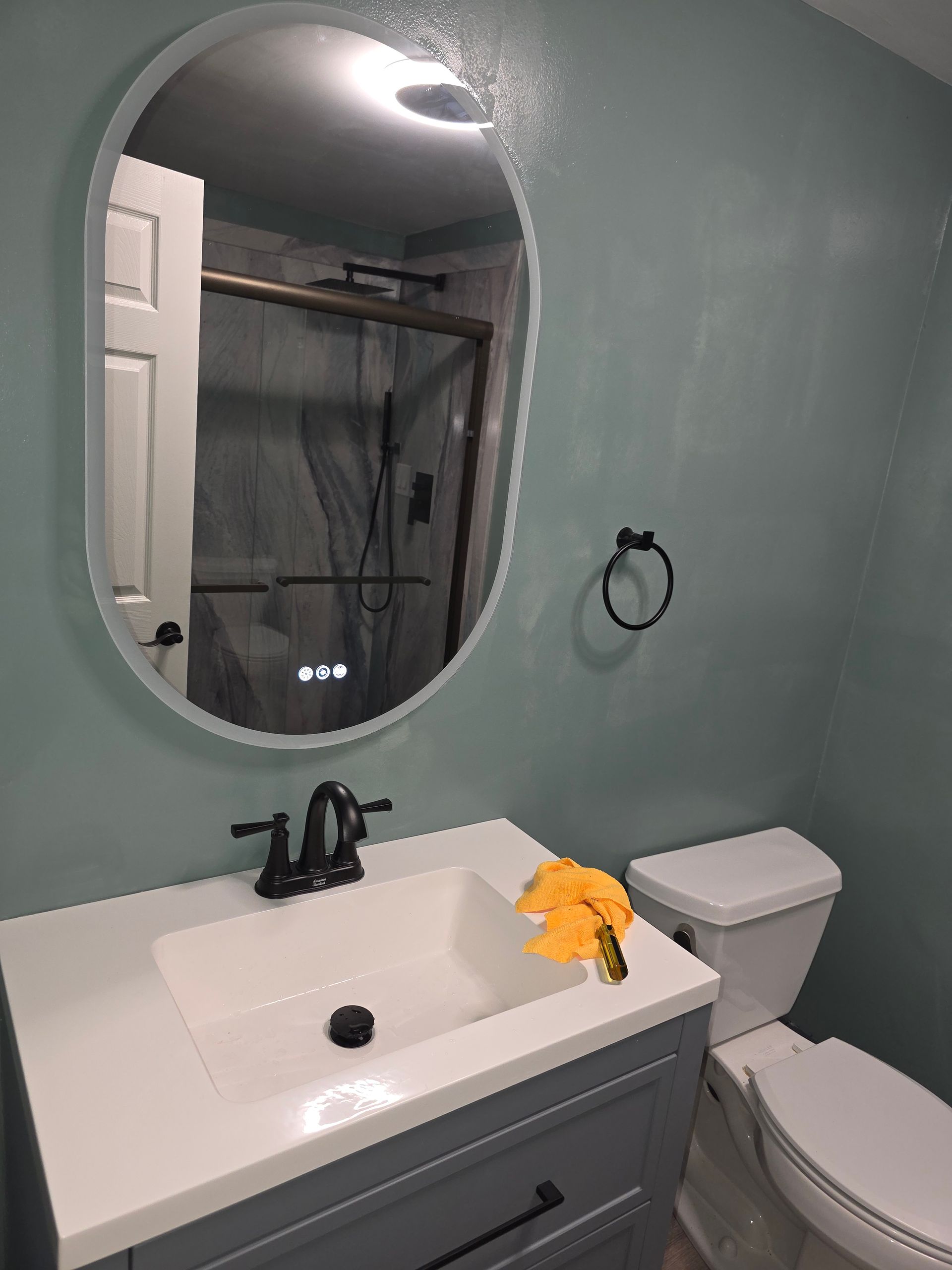 A bathroom with a sink , toilet and mirror.