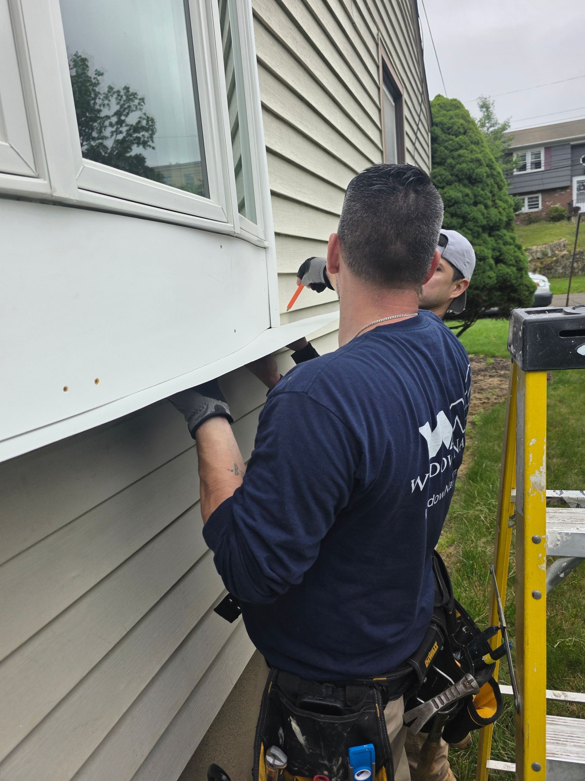 A man is working on the side of a house.