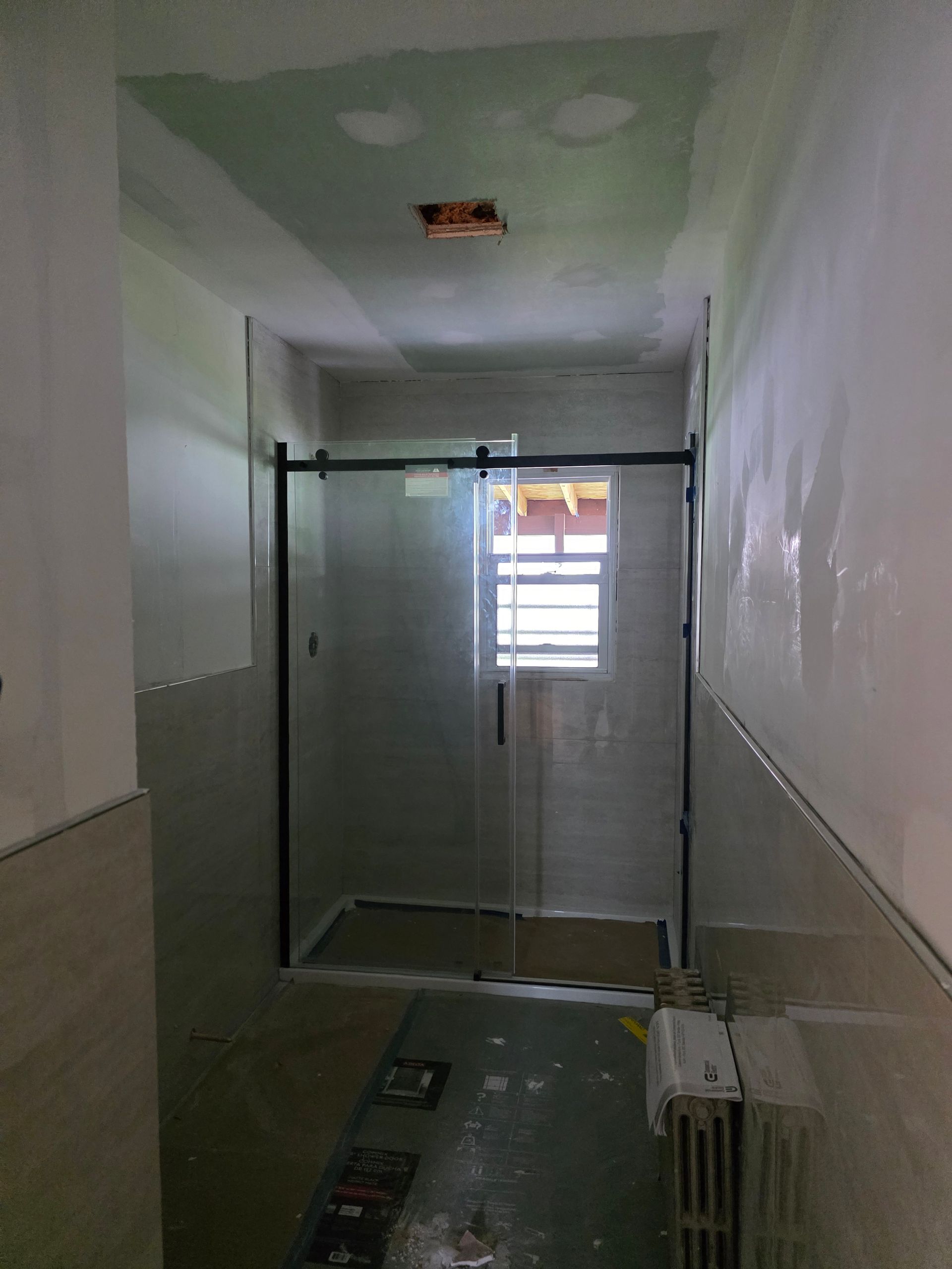 A bathroom with a sliding glass door and a window.