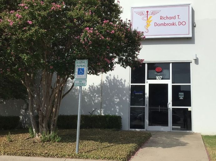 A white building with a handicapped parking sign in front of it