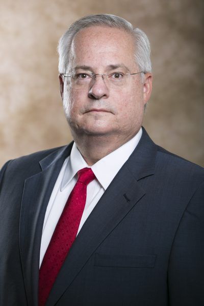 A man in a suit and tie is looking at the camera