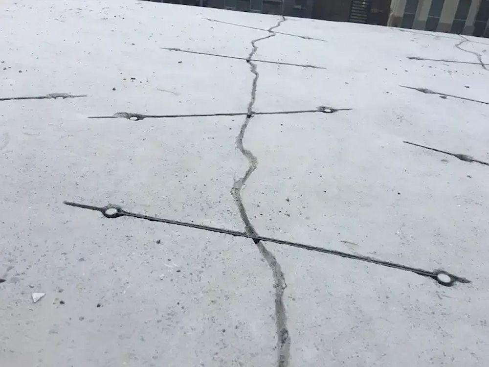 Concrete Surface With Several Cracks and Metal Ring Anchors — Consider it Sealed Waterproofing in Crangan Bay, NSW