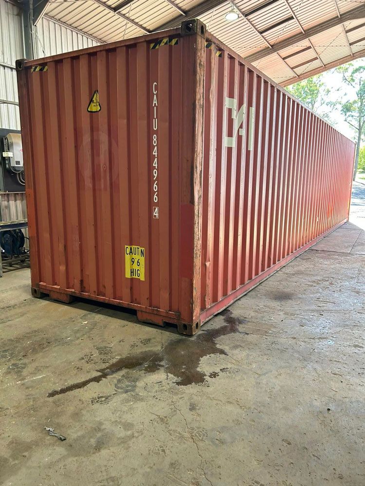 A Large Red Shipping Container Is Sitting in A Garage — Ries Trucking in Gowrie Mountain, QLD