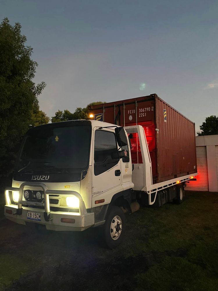 White Truck Is Parked Next To A Red Shipping Container — Ries Trucking in Gowrie Mountain, QLD