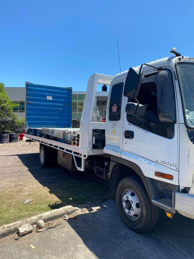 A White Tow Truck With A Blue Container On The Back — Ries Trucking in Gowrie Mountain, QLD