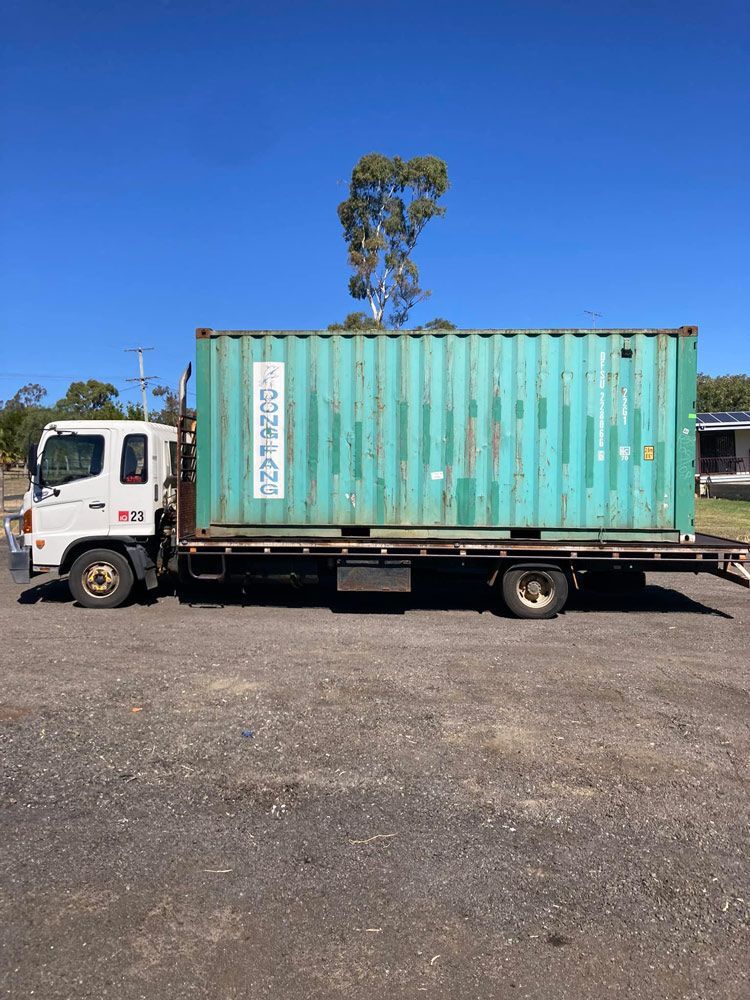 A Green Shipping Container Is Sitting On The Back of A Tow Truck — Ries Trucking in Gowrie Mountain, QLD