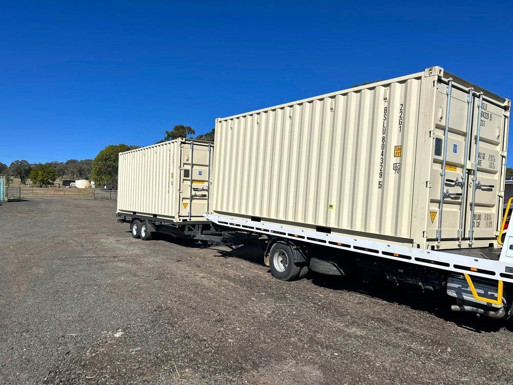 Two Shipping Containers Are Sitting On Top Of A Flatbed Truck — Ries Trucking in Gowrie Mountain, QLD