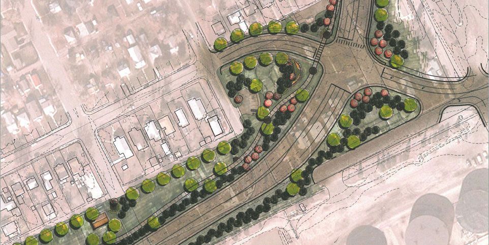 Aerial view of a landscaped park with curving paths, trees, and nearby roads in a sandy urban area