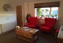 Podiatry clinic interior view with red armchairs