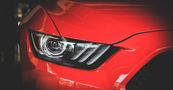 A close up of a red car 's headlight.