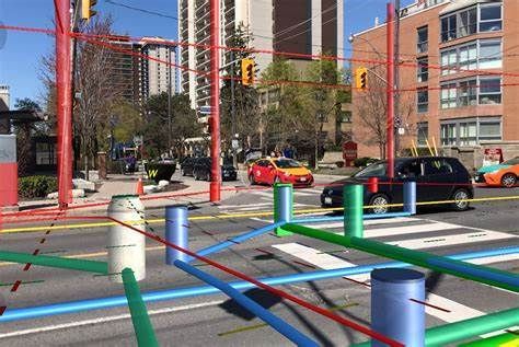 A car is driving down a street surrounded by colorful poles.