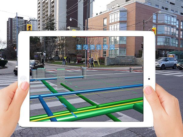A person is holding a tablet with a picture of a street on it.