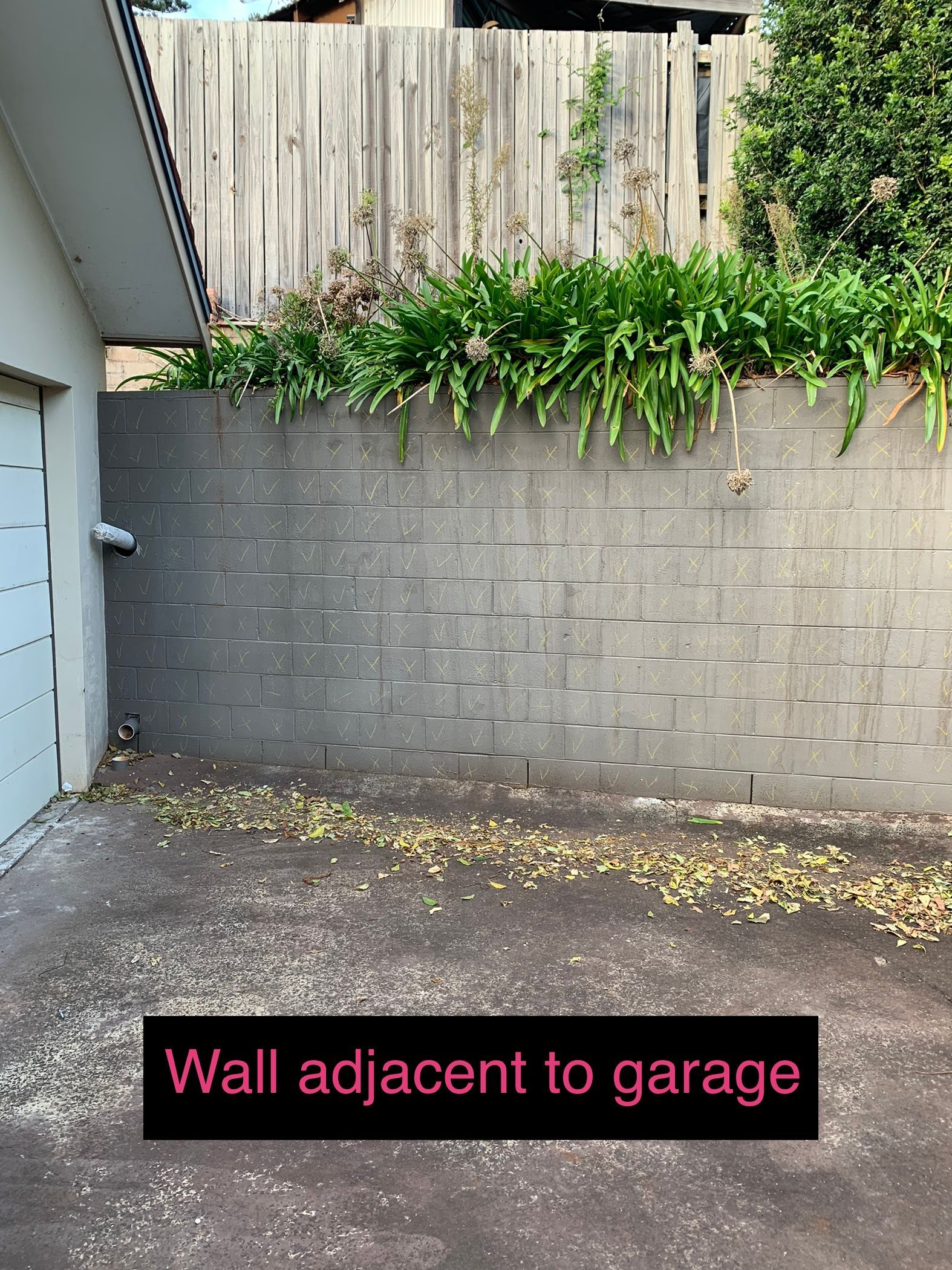 A picture of a wall adjacent to a garage.