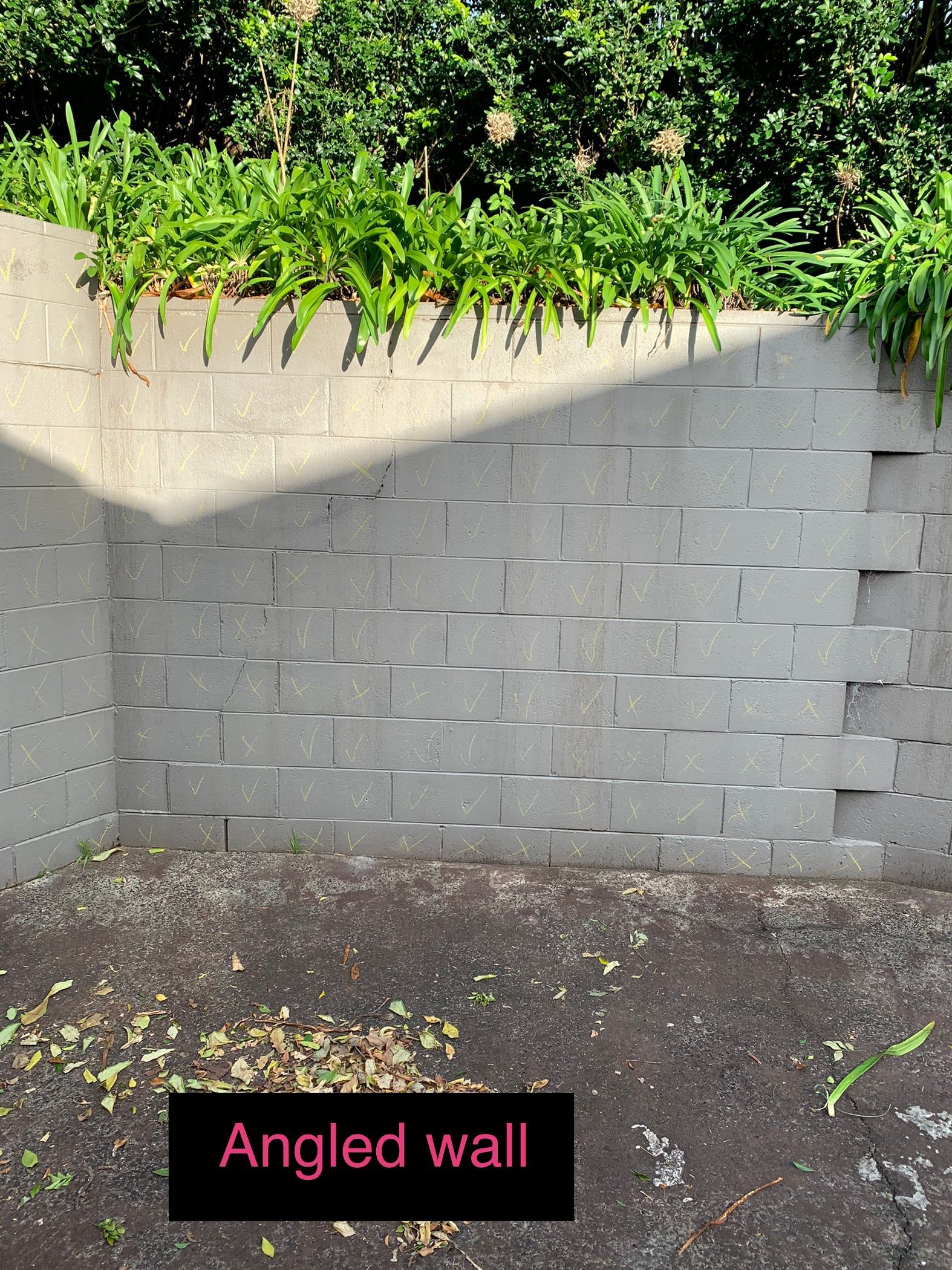 A brick wall with a sign that says angled wall