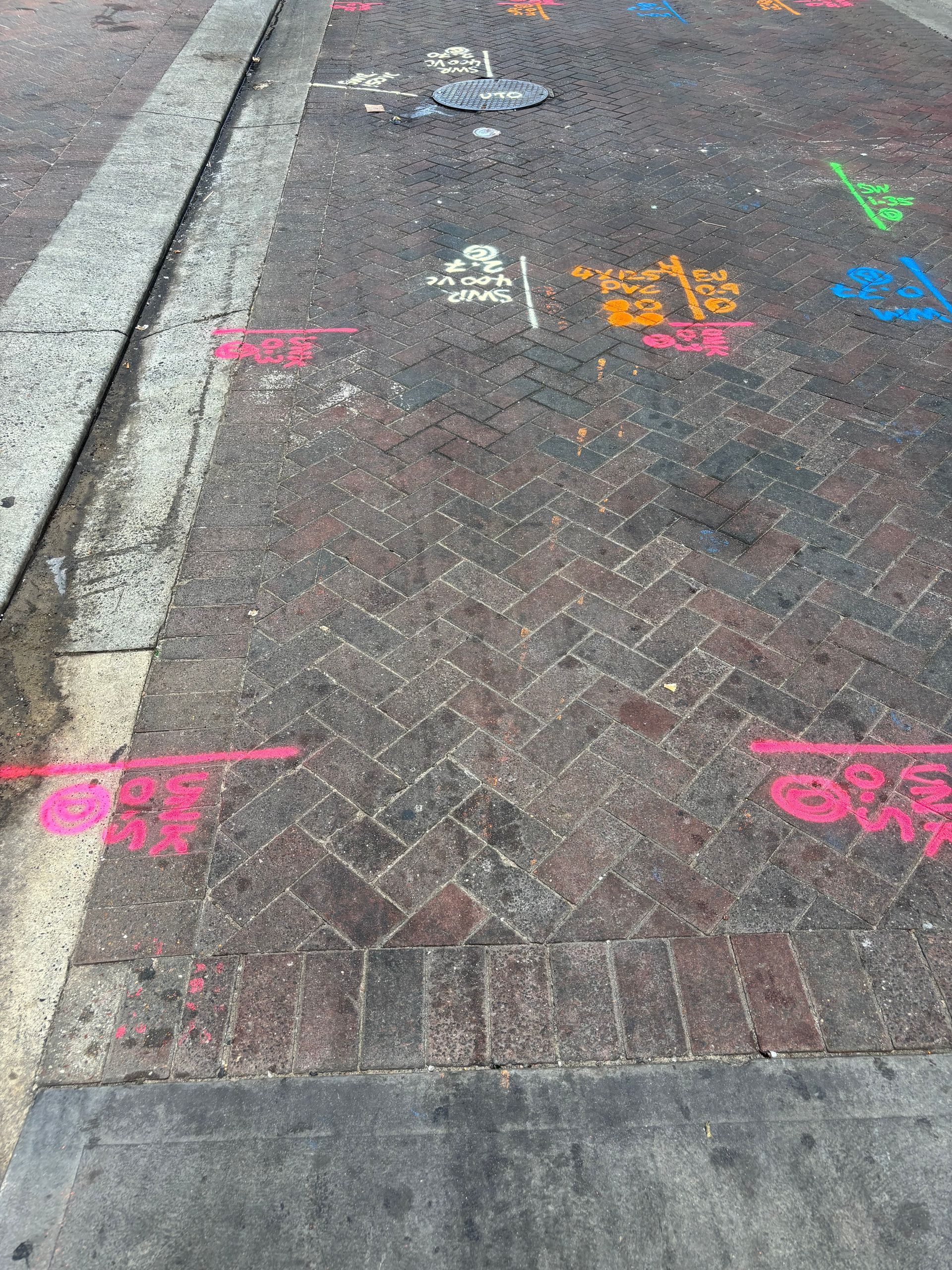 A brick sidewalk with colorful chalk drawings on it.