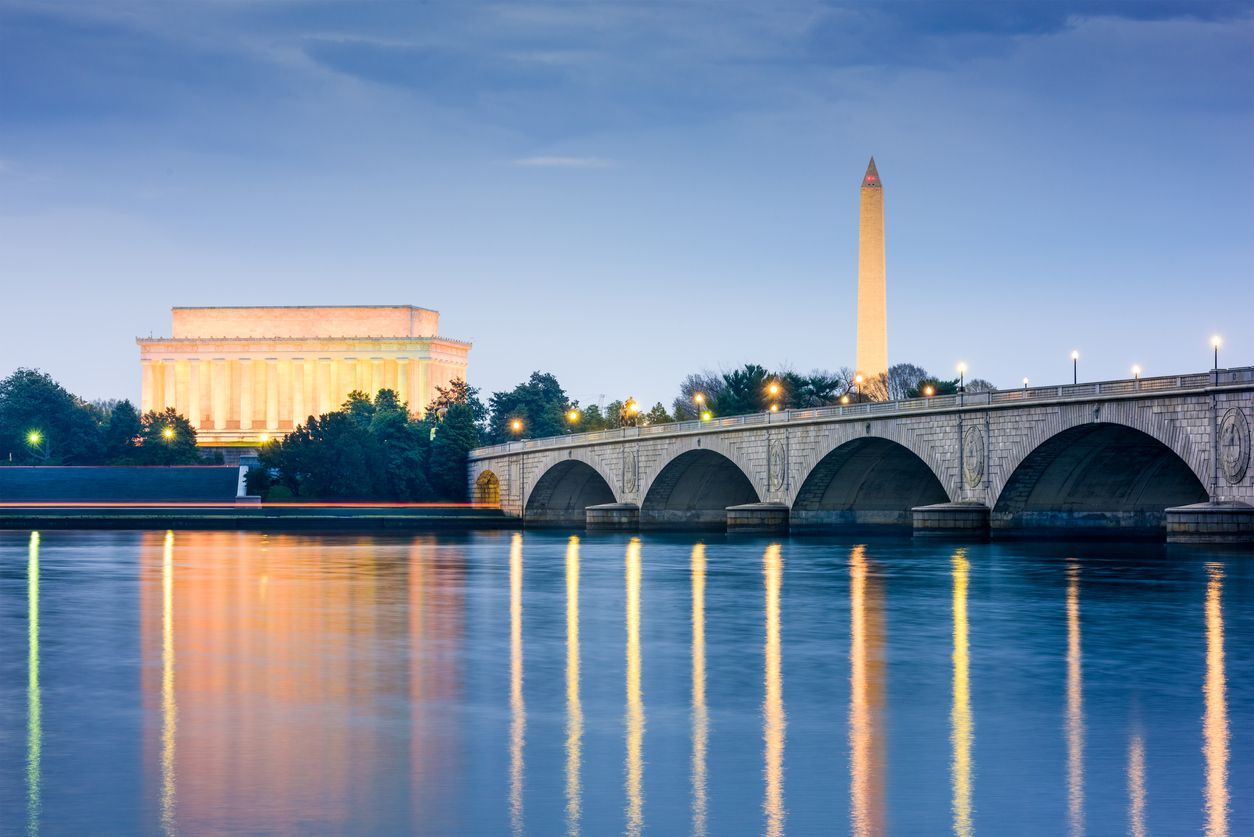 A bridge over a body of water with the lincoln memorial in the background.