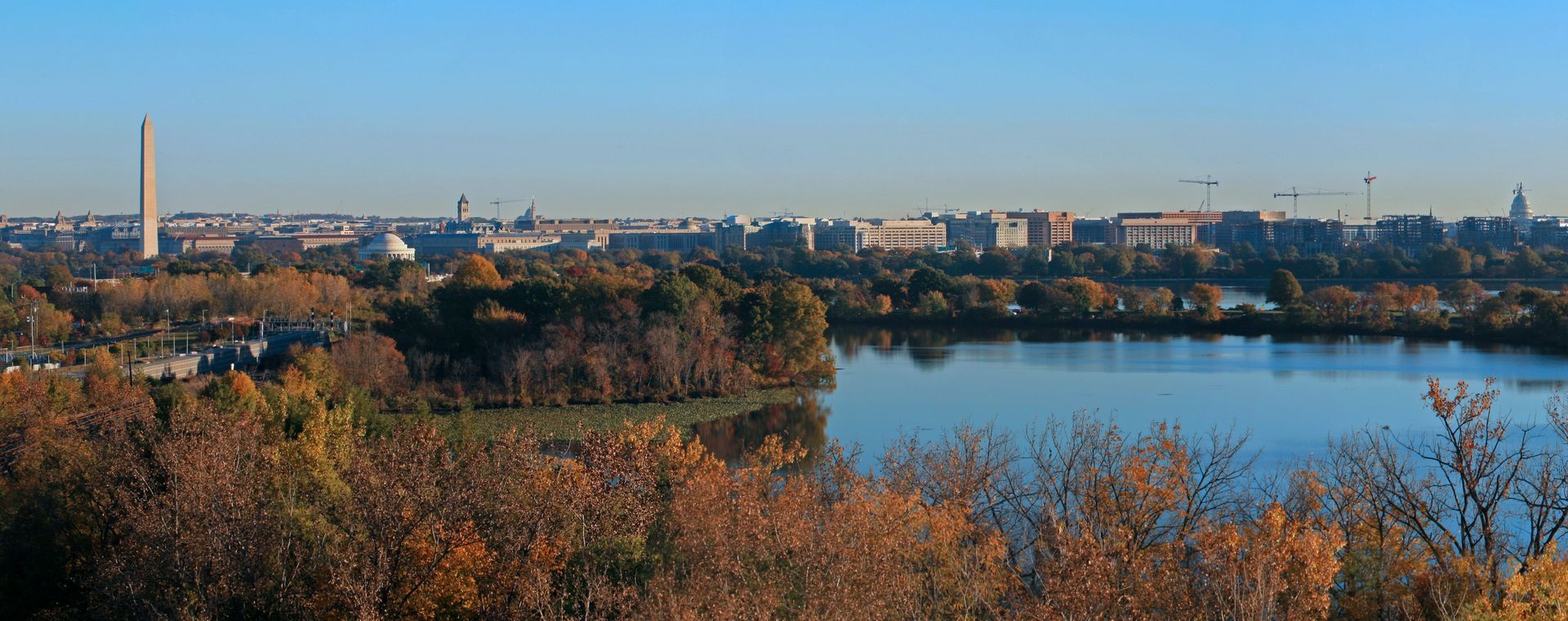 A large body of water with trees in the foreground and DC city in the background.
