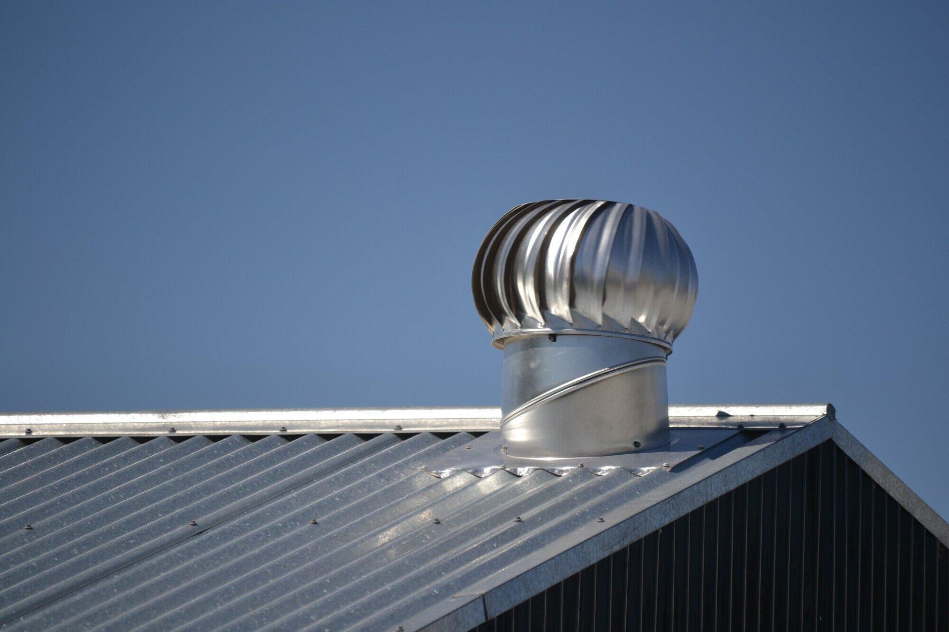 A metal roof with a turbine on top of it