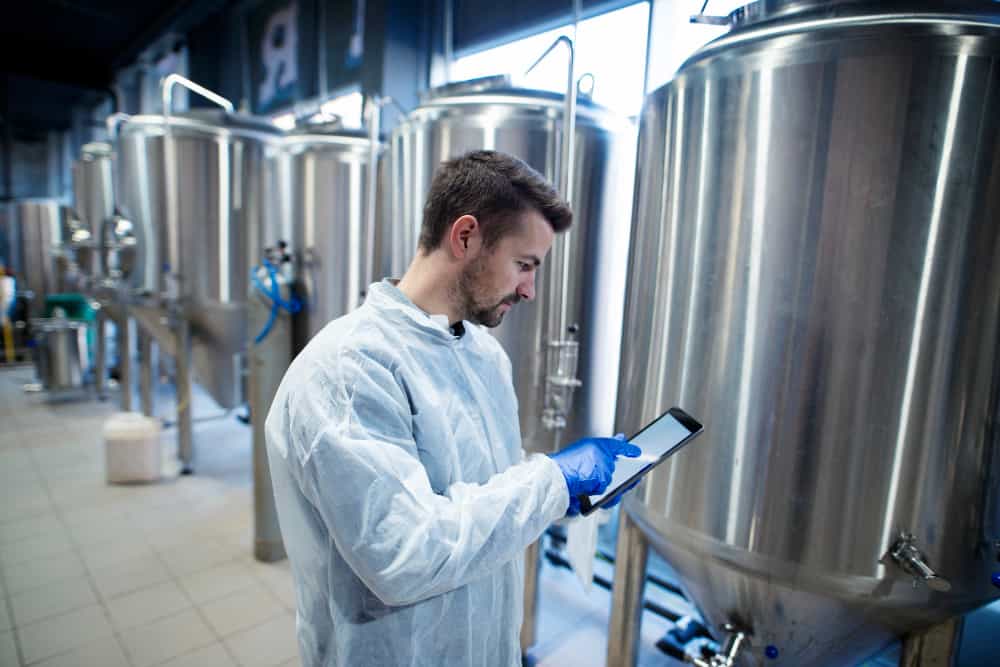 a man is using a tablet in a brewery .