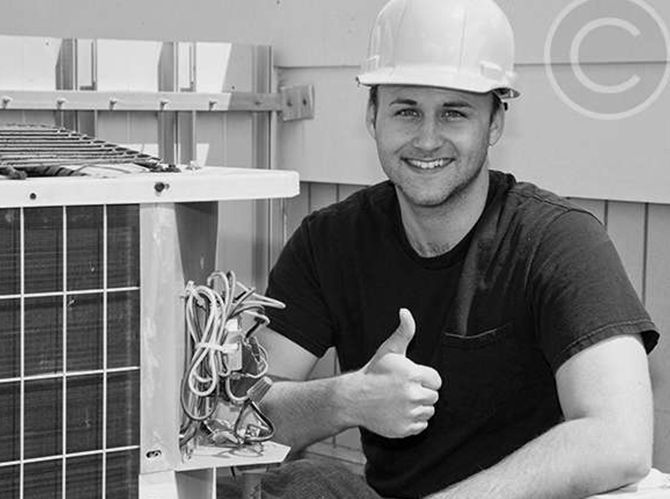 A man wearing a hard hat is giving a thumbs up.