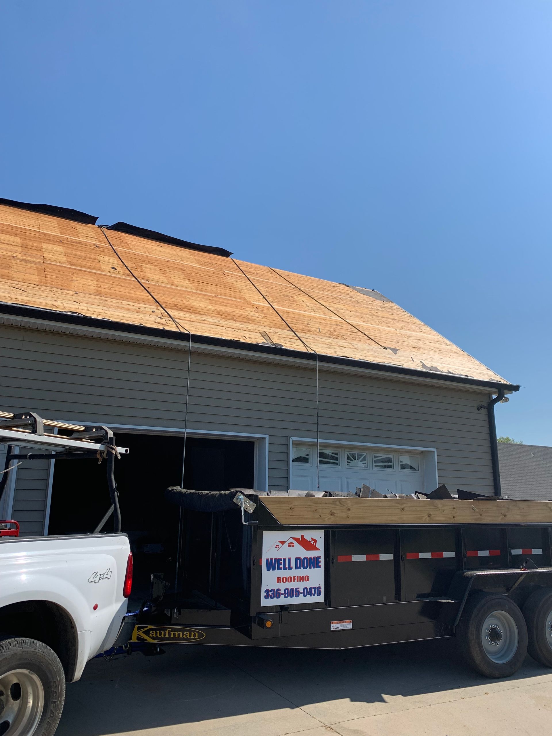 A truck is parked in front of a building with a trailer attached to it.