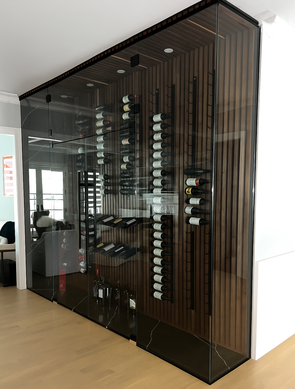 Wine cellar with glass walls, wooden interior, and rows of wine bottles on display. Birmingham, MI