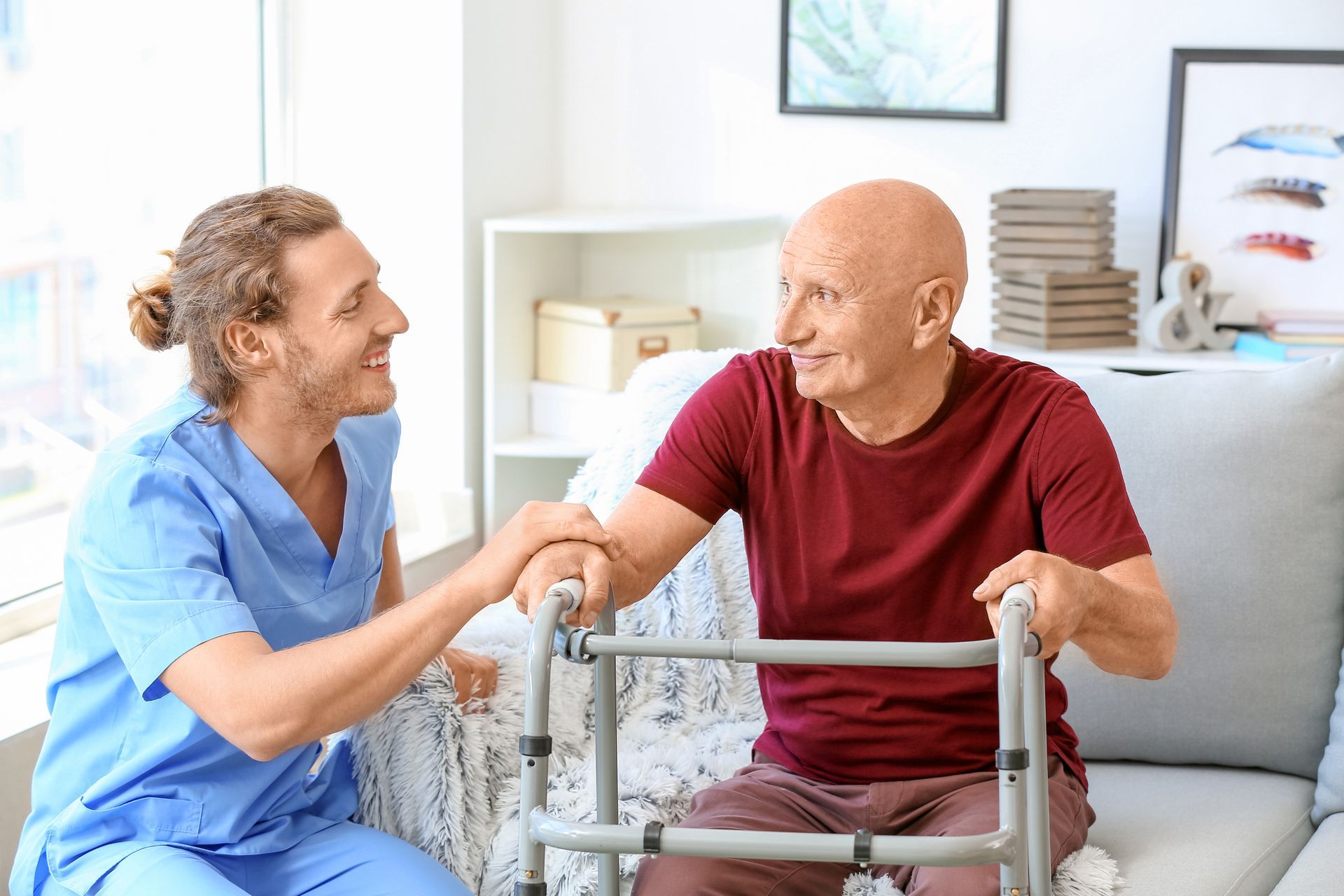 A nurse is helping an elderly man with a walker.