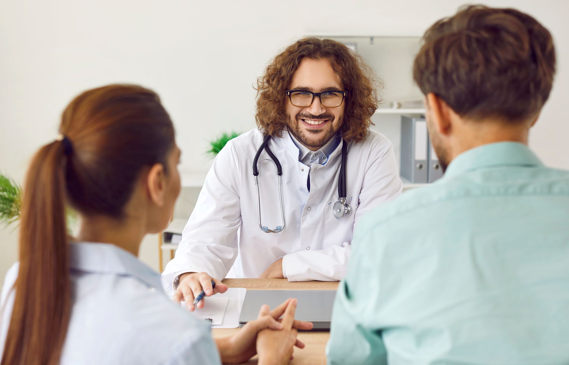 A doctor is talking to a patient and his wife.